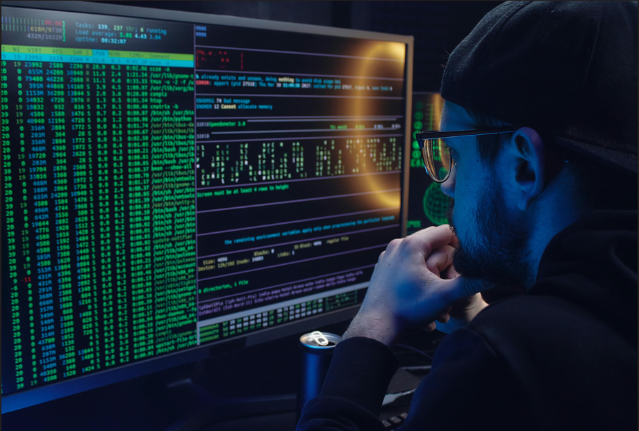 Guy with glasses looking at codes on big screen