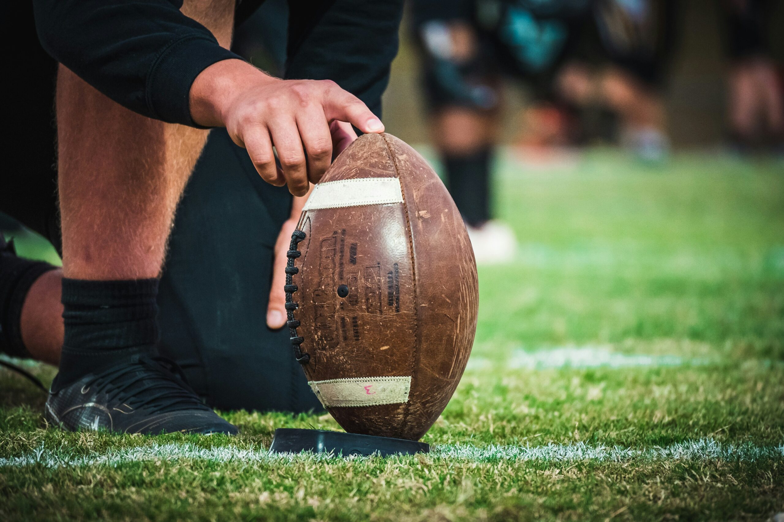 Player with a finger on a rugby ball on the field