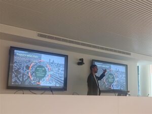 Person giving a presentation in front of two screens